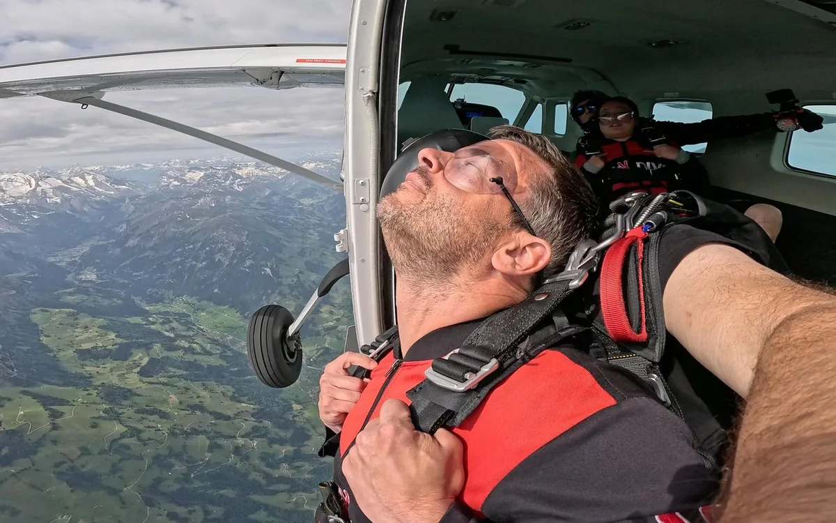 Tandem skydiver in freefall above the snow-covered Swiss Alps near Interlaken